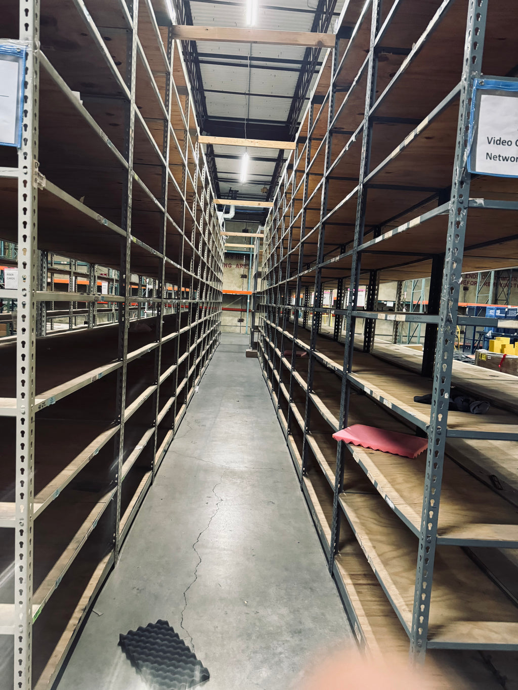 Long aisle in a warehouse with high shelves on both sides