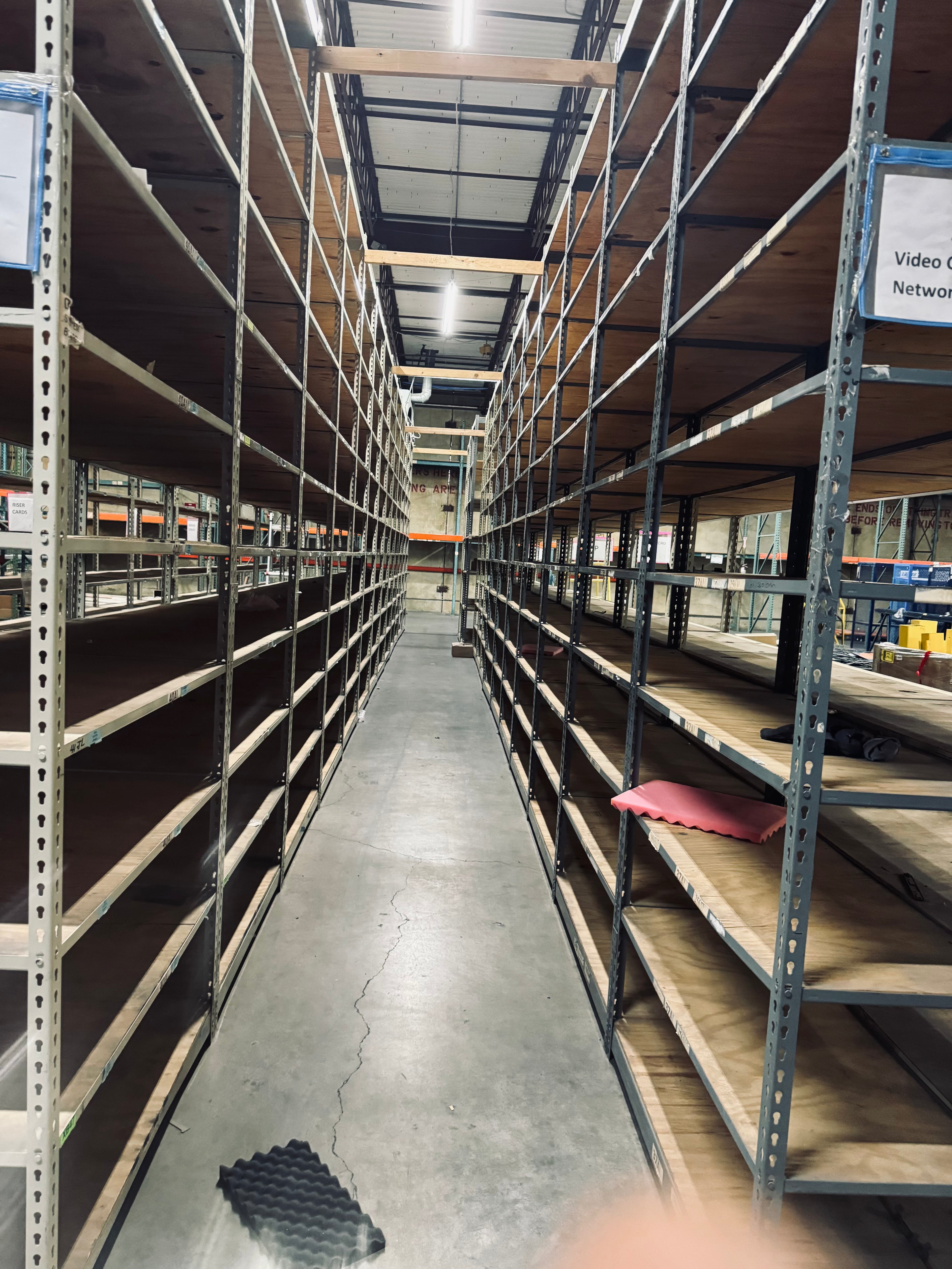 Long aisle in a warehouse with high shelves on both sides