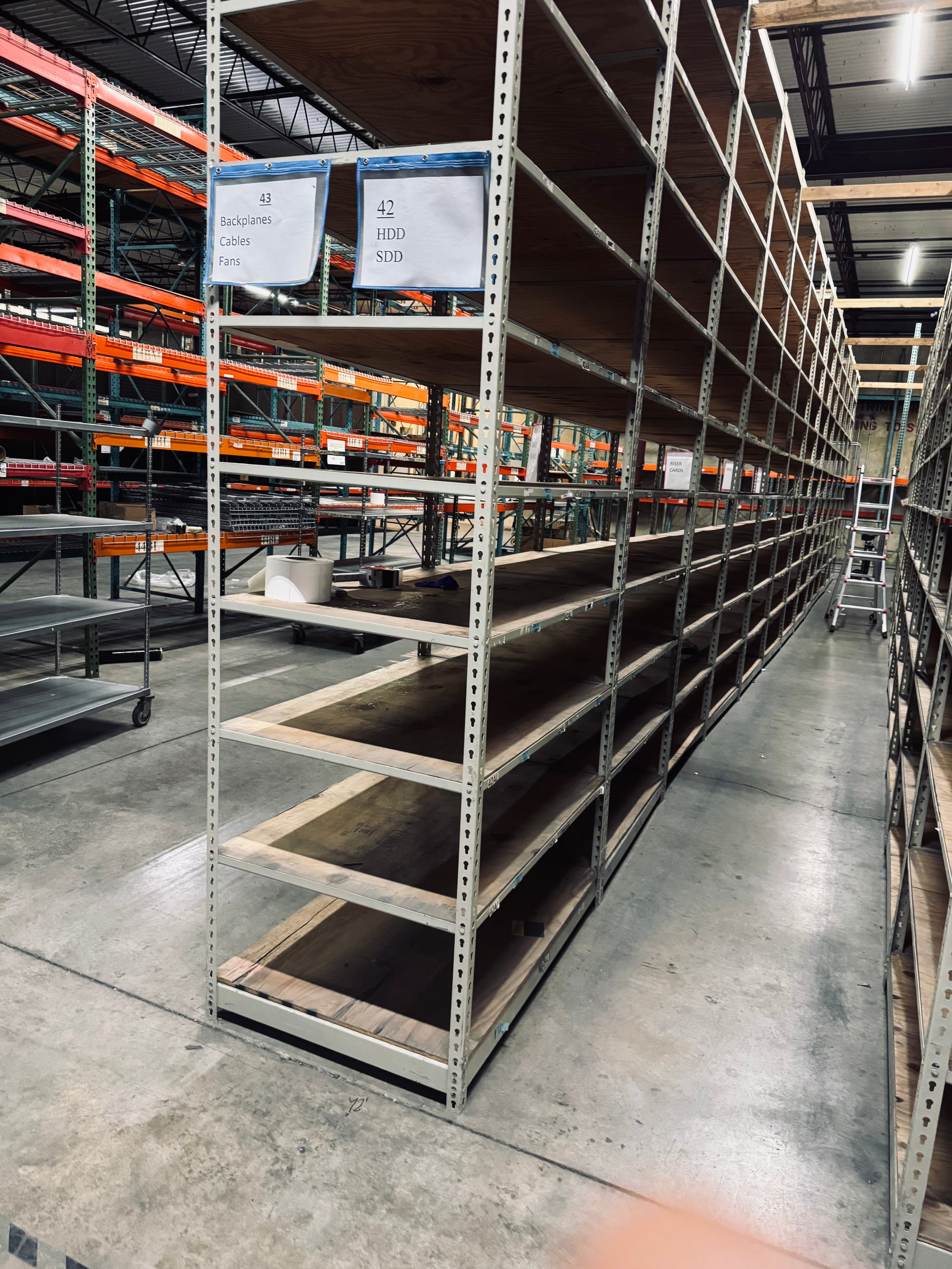 Empty warehouse shelves with labels in a large storage facility.